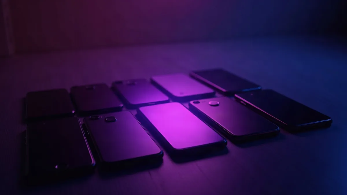 Several smartphones lined up, a purple spotlight on the middle one (article illustration)